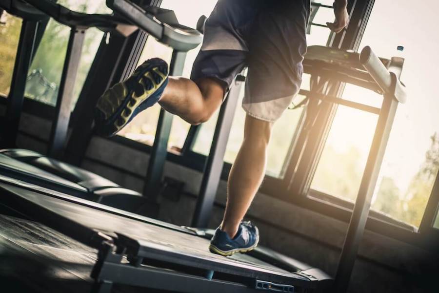 Lower half of man running on treadmill