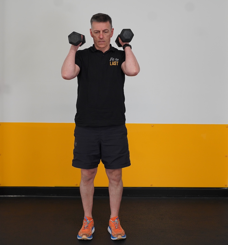 man performing overhead press with dumbbells to show how to strength train in your sixties