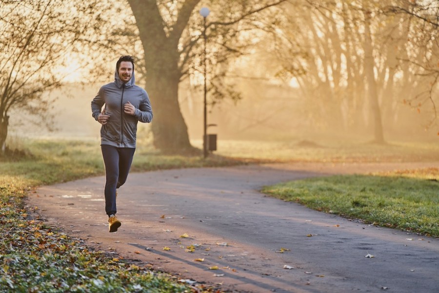 Male jogger in the park on sunny autumn morning