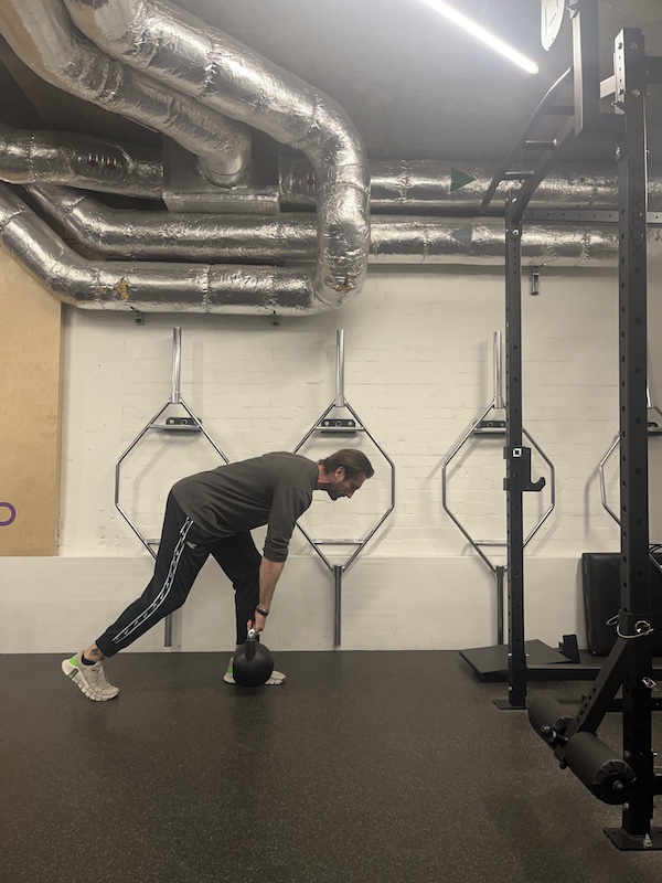 man performing kettlebell 'B stance' RDL in the gym