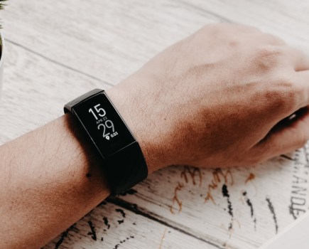 man's hand with Fitbit on wrist