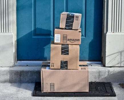 pile of amazon boxes on doorstep