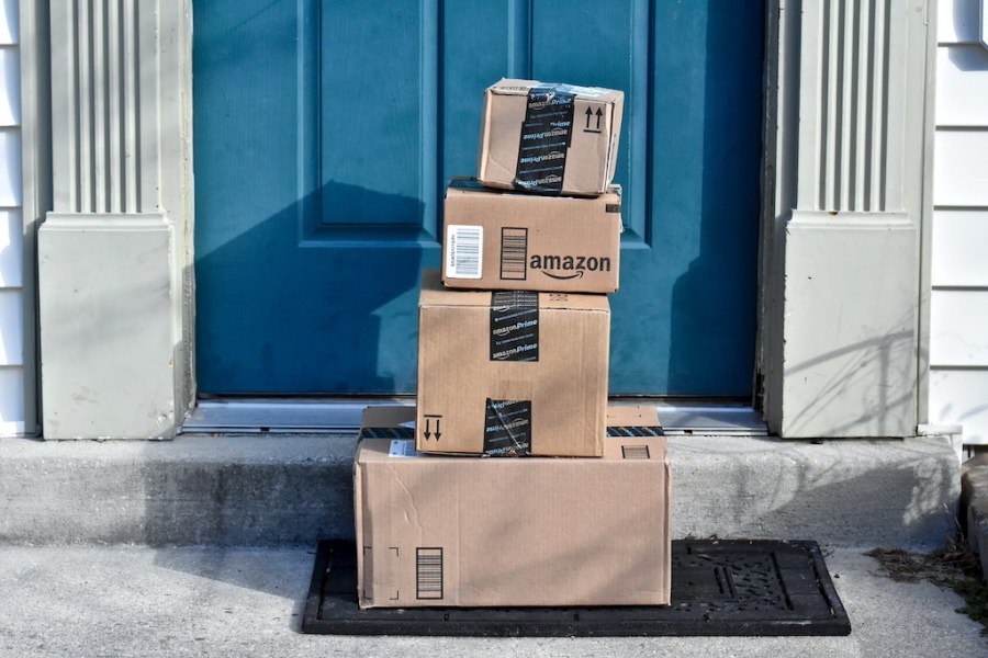 pile of amazon boxes on doorstep