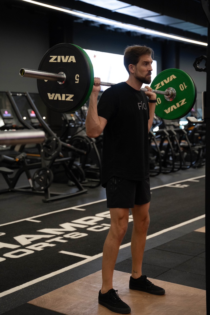 PT demonstrating how to perform a barbell back squat