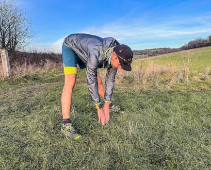 running coach Simon James performs a hamstring stretch as part of a post-run stretching routine