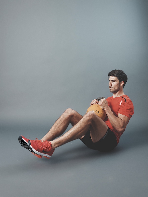 man in fitness kit demonstrating how to do a kettlebell crunch