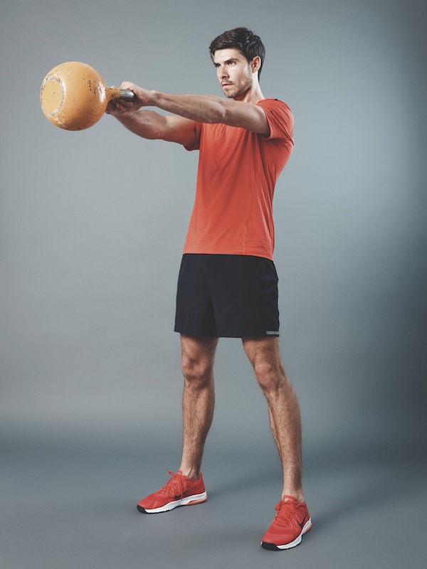 man in fitness kit demonstrating how to do a kettlebell swing