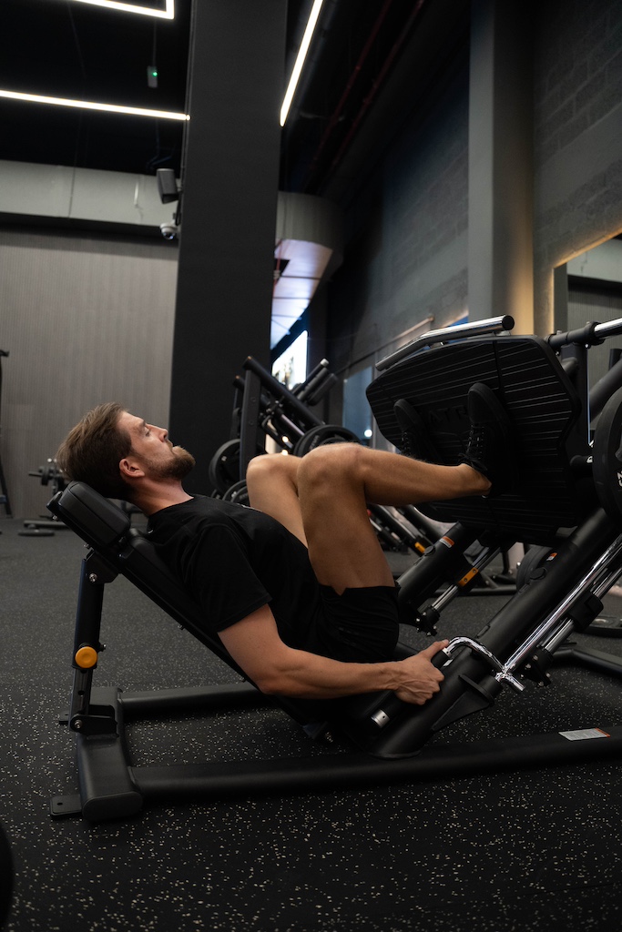 PT demonstrating how to perform a leg press