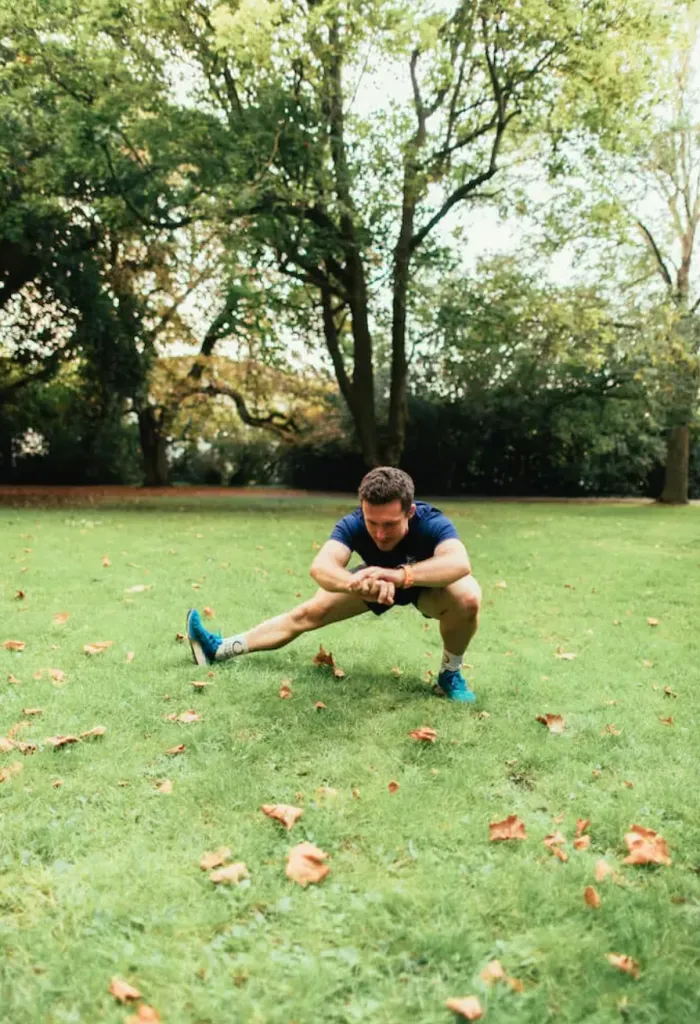 Man performing a side lunge in a park