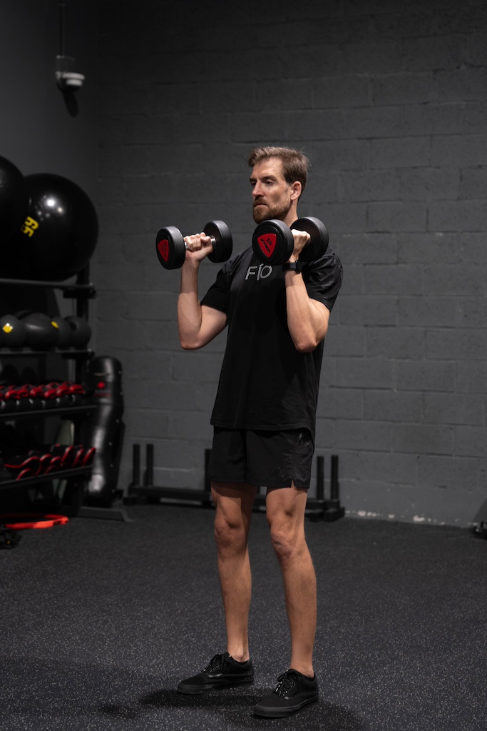 PT demonstrating how to perform a shoulder press