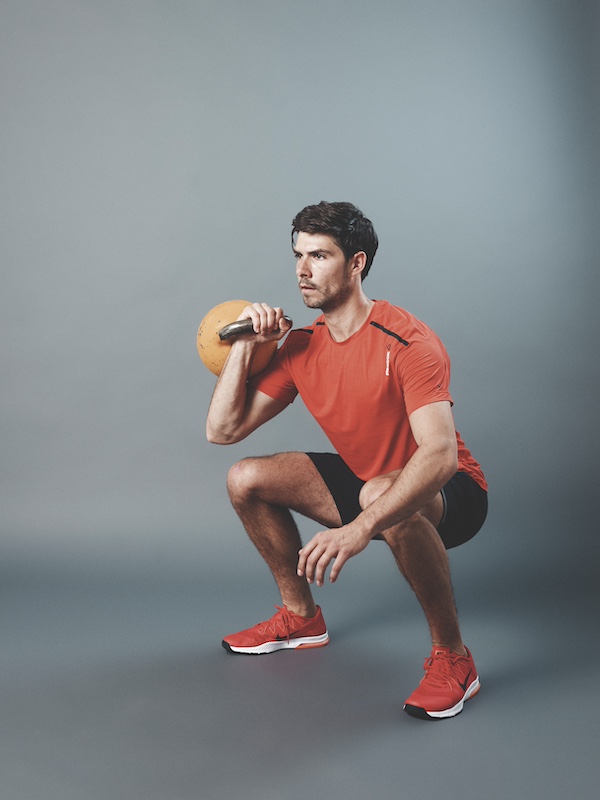 fitness model demonstrating how to do the kettlebell Sots press