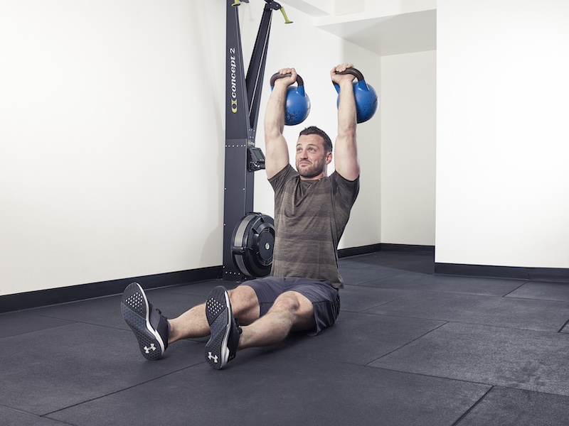 fitness model demonstrating how to perform a kettlebell angel press – one of the best kettlebell abs exercises