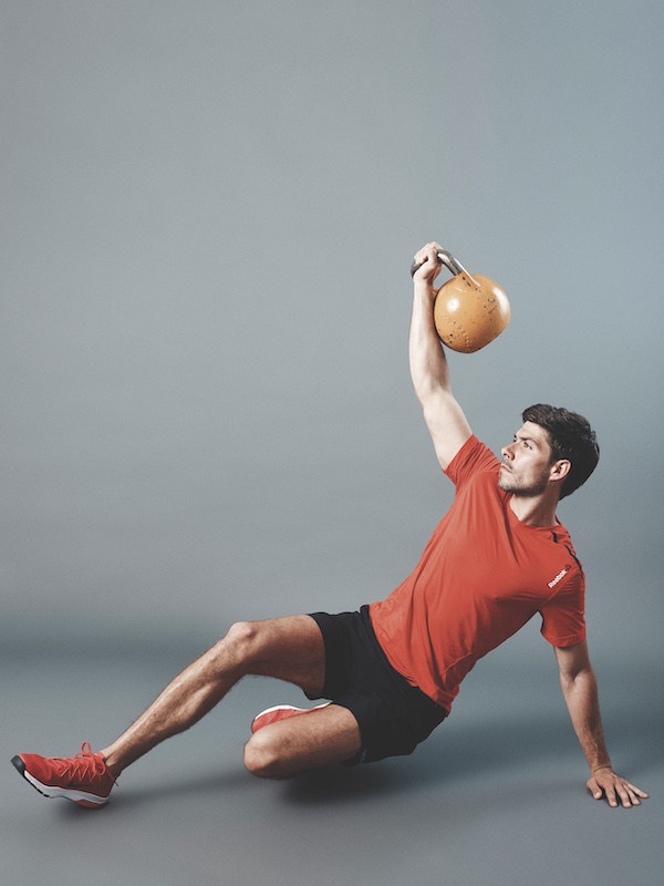 fitness model demonstrating how to do the kettlebell Turkish get-up as part of a kettlebell workout