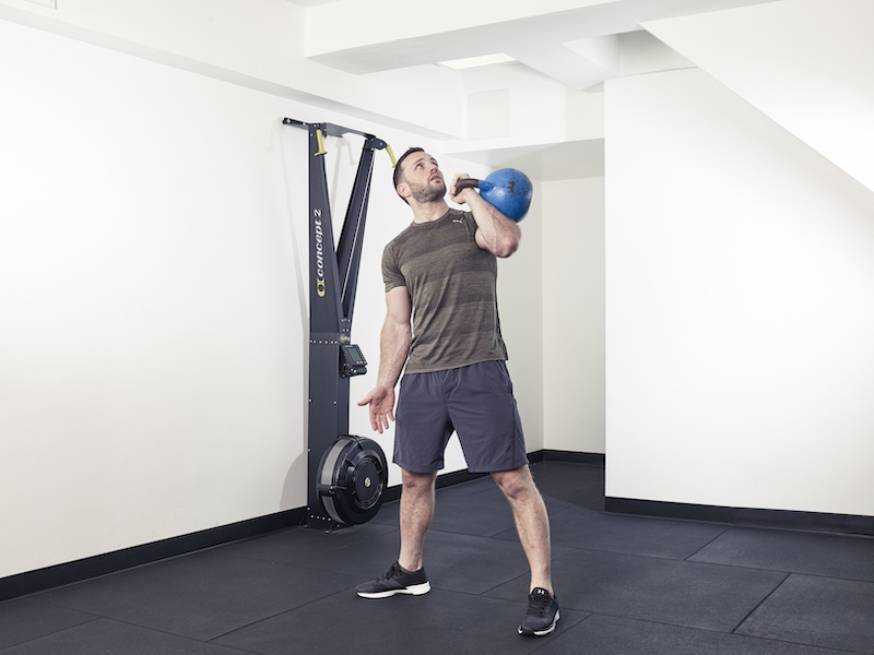 fitness model demonstrating how to perform a kettlebell bent press – one of the best kettlebell abs exercises