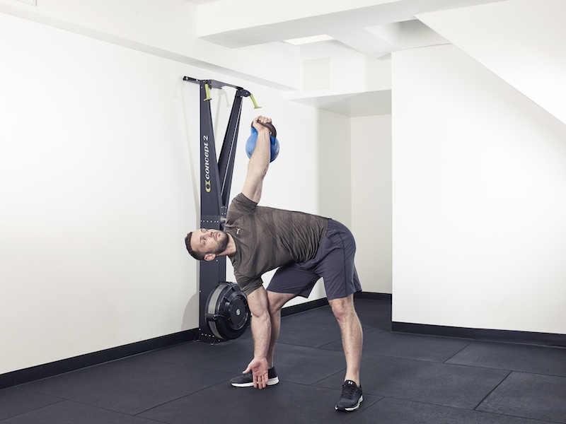 fitness model demonstrating how to perform a kettlebell bent press – one of the best kettlebell abs exercises