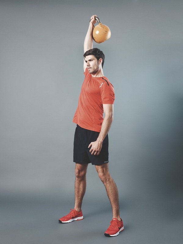 fitness model demonstrating how to do the kettlebell clean and press