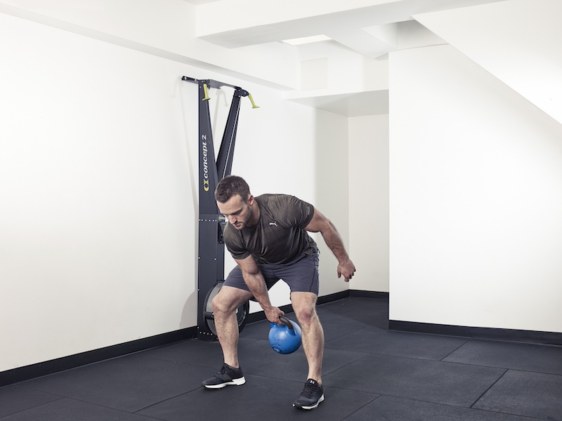 fitness model demonstrating how to perform a kettlebell figure of eight – one of the best kettlebell abs exercises