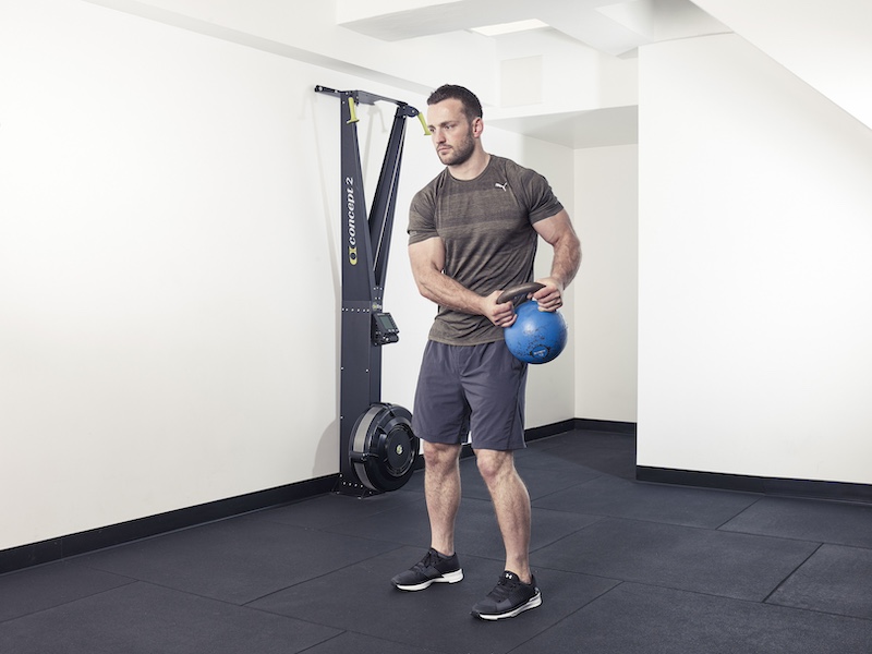 fitness model demonstrating how to perform a kettlebell halo – one of the best kettlebell abs exercises