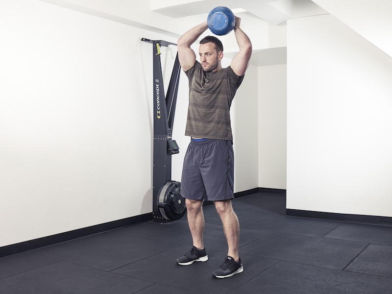 fitness model demonstrating how to perform a kettlebell halo – one of the best kettlebell abs exercises