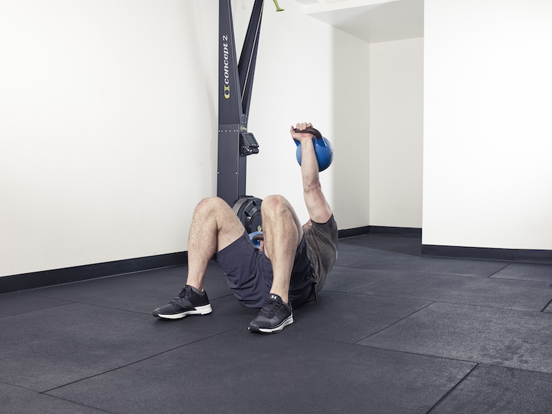 fitness model demonstrating how to perform a kettlebell rolling thunder