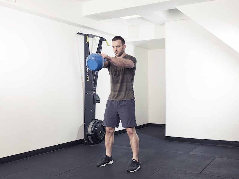 fitness model demonstrating how to perform a kettlebell round the world