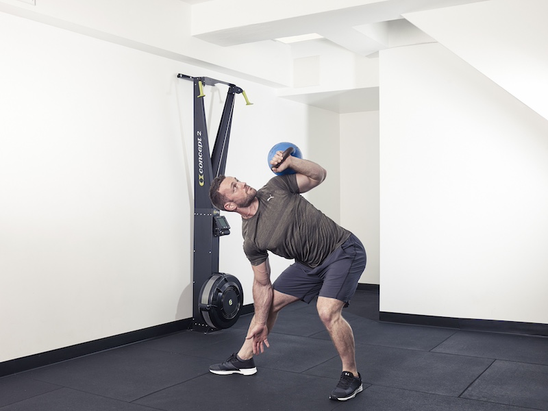 fitness model demonstrating how to perform a kettlebell side press