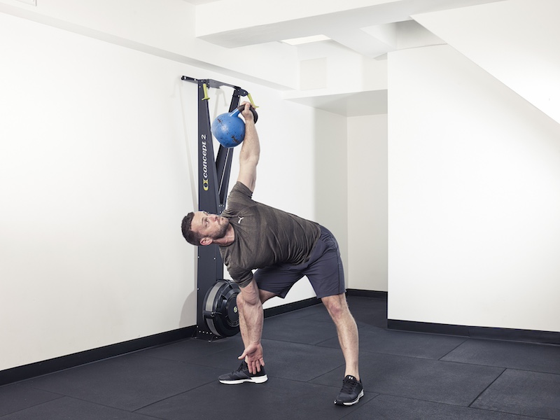 fitness model demonstrating how to perform a kettlebell side press