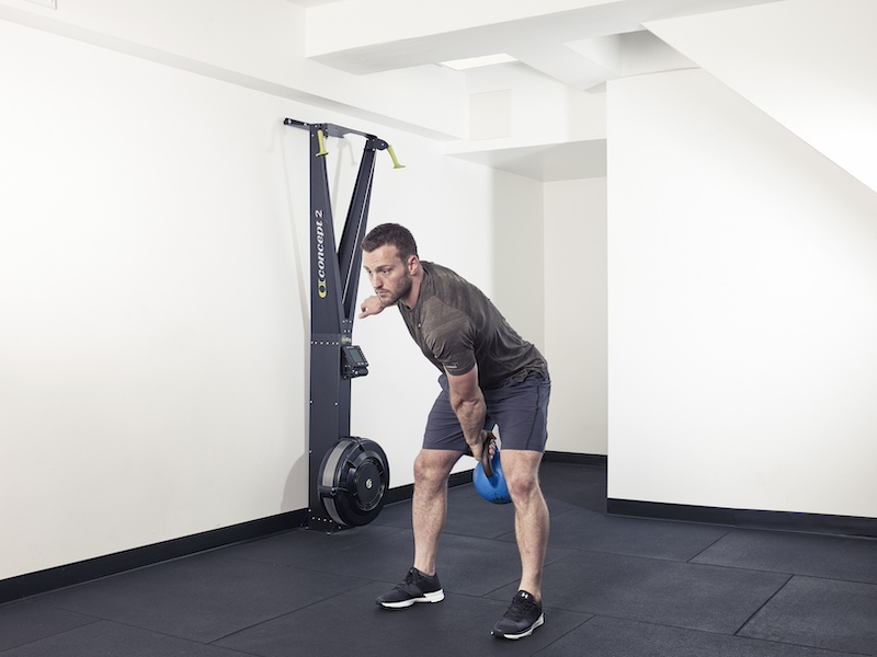 fitness model demonstrating how to perform a kettlebell snatch