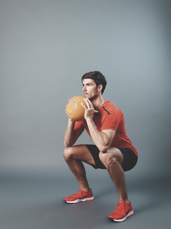 fitness model demonstrating how to do the kettlebell thruster 