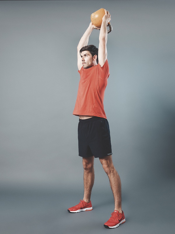 fitness model demonstrating how to do the kettlebell thruster 