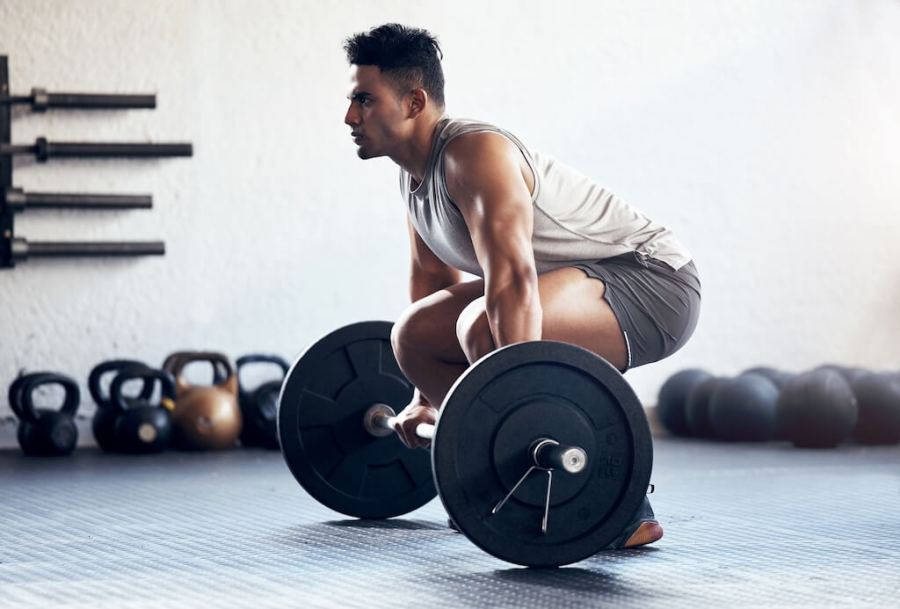 man in gym performing deadlift as part of a New Year Workout Plan