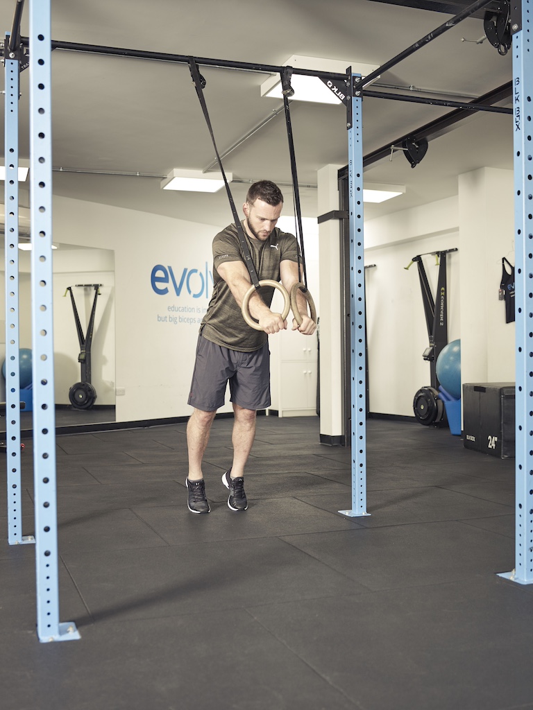 man performing a flye with a suspension trainer