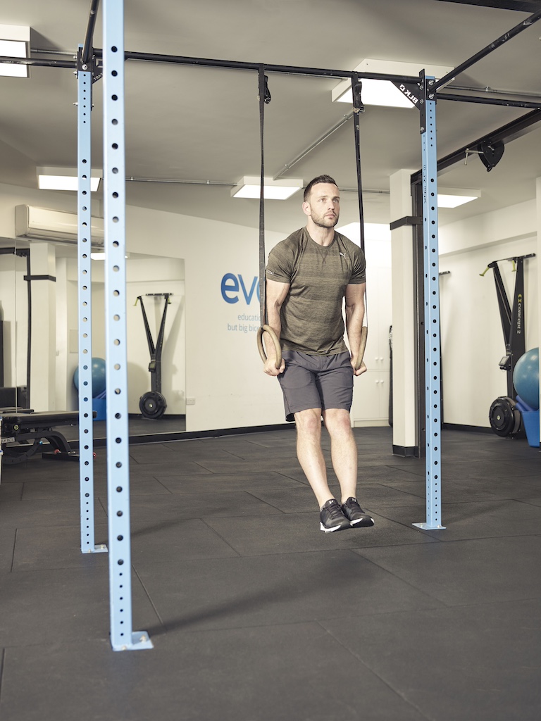 man performing a ring hold with a suspension trainer