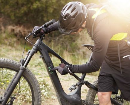 A mountain biker switching on his e-bike