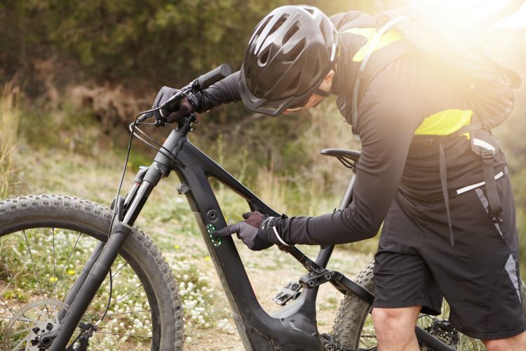 A mountain biker switching on his e-bike