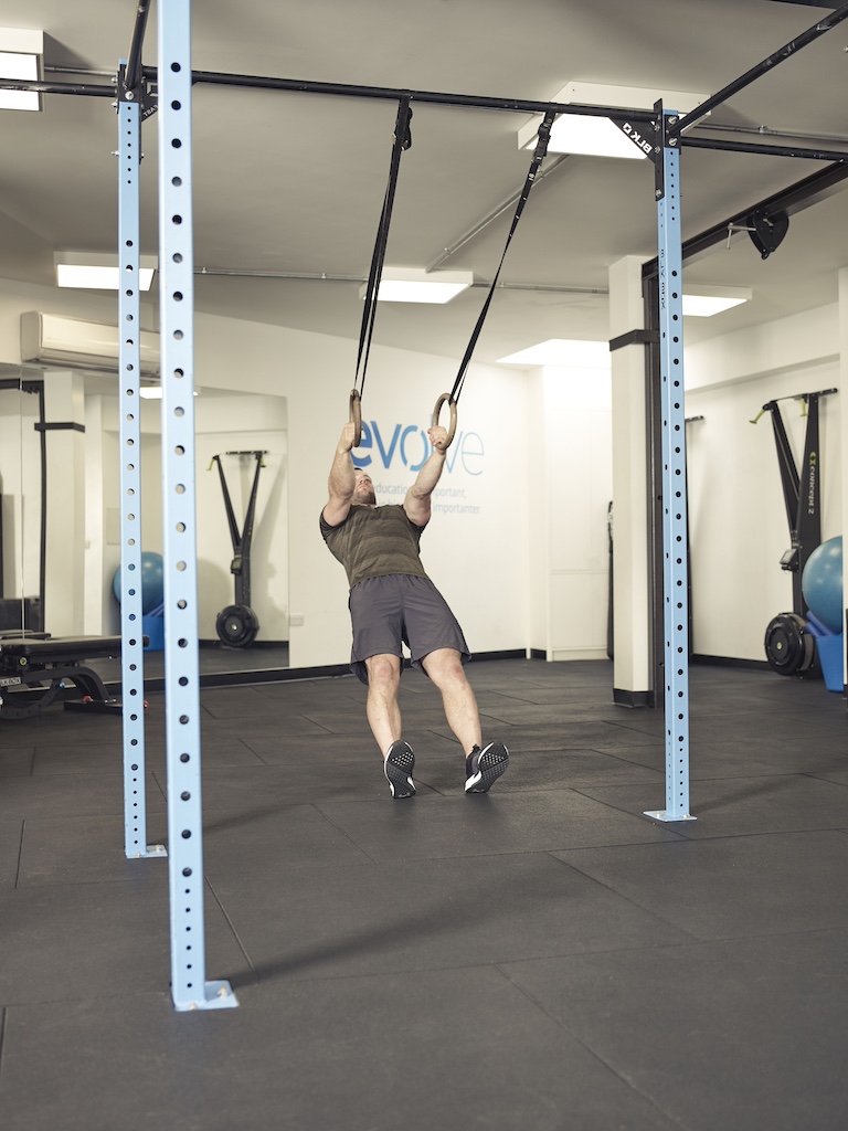 man performing an inverted row suspension trainer abs exercise