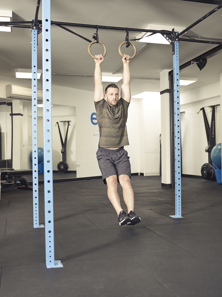 man performing a knee raise suspension trainer abs exercise