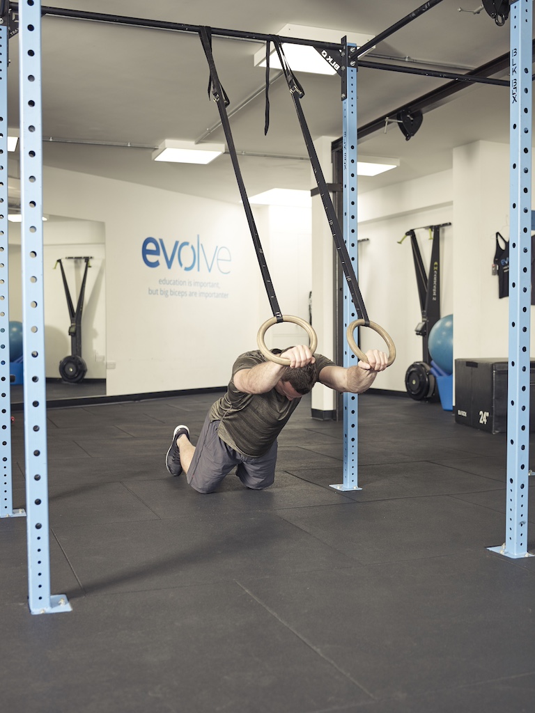 man performing a kneeling rollout