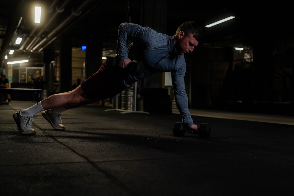 man performing renegade row as part of a small-space dumbbell workout