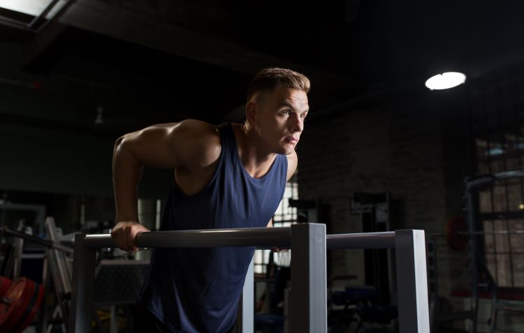 Man performing triceps dip on parallel bars