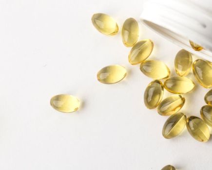 Vitamin D capsules spilling out of a jar