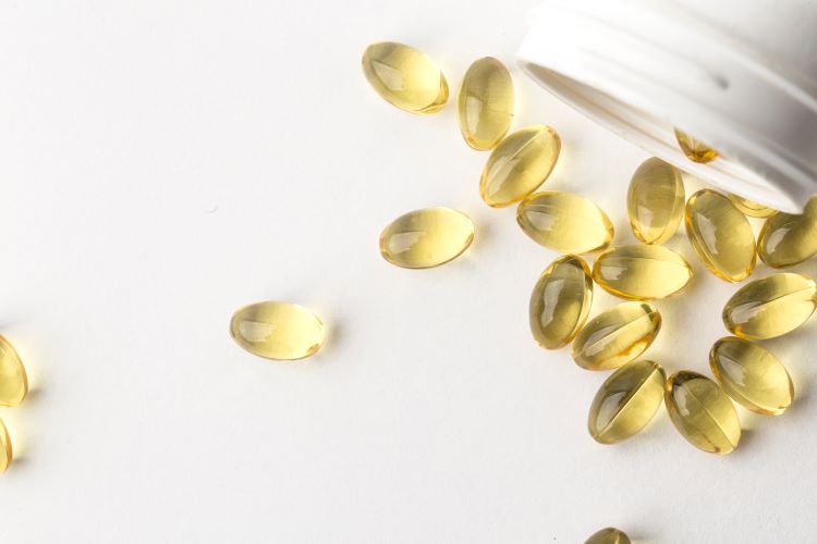 Vitamin D capsules spilling out of a jar