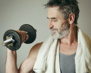 Man with grey hair exercising with dumbbells