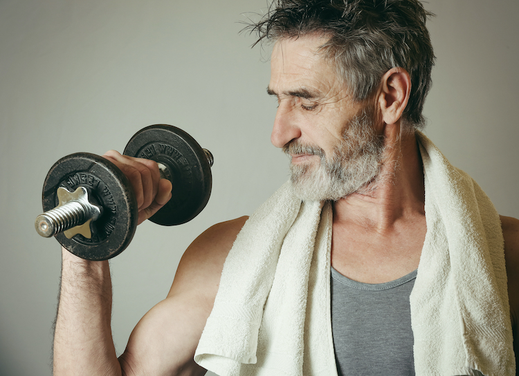 Man with grey hair exercising with dumbbells