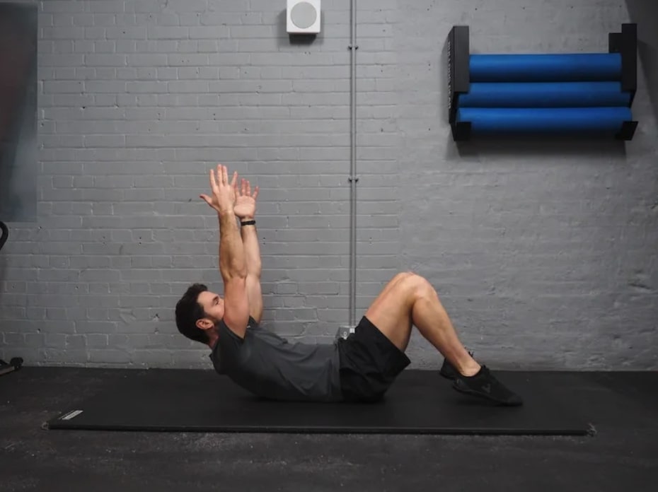 man performing deadbug iso hold as part of one of the best core workouts for men