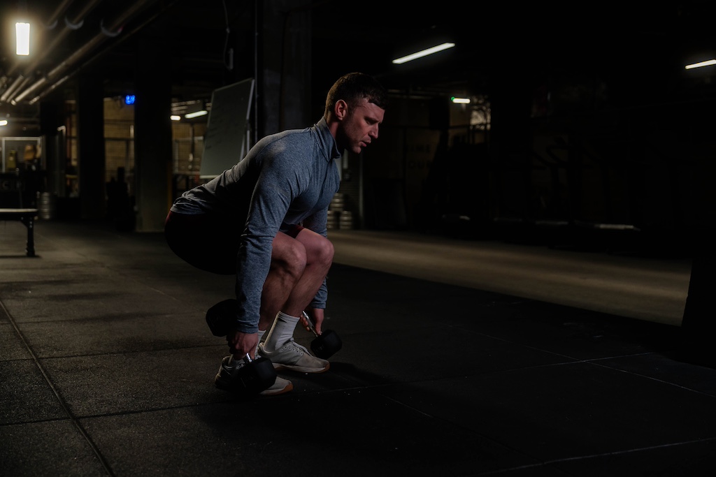 man performing dumbbell deadlift in the gym