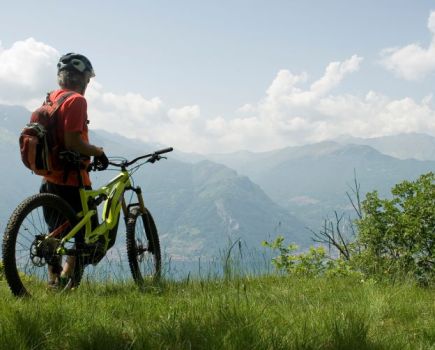 Man on e-bike with mountains in the distance