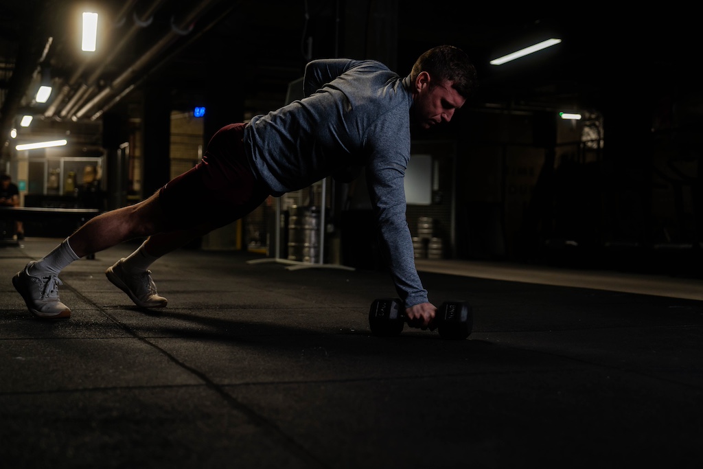 man performing renegade row as part of a small-space dumbbell workout