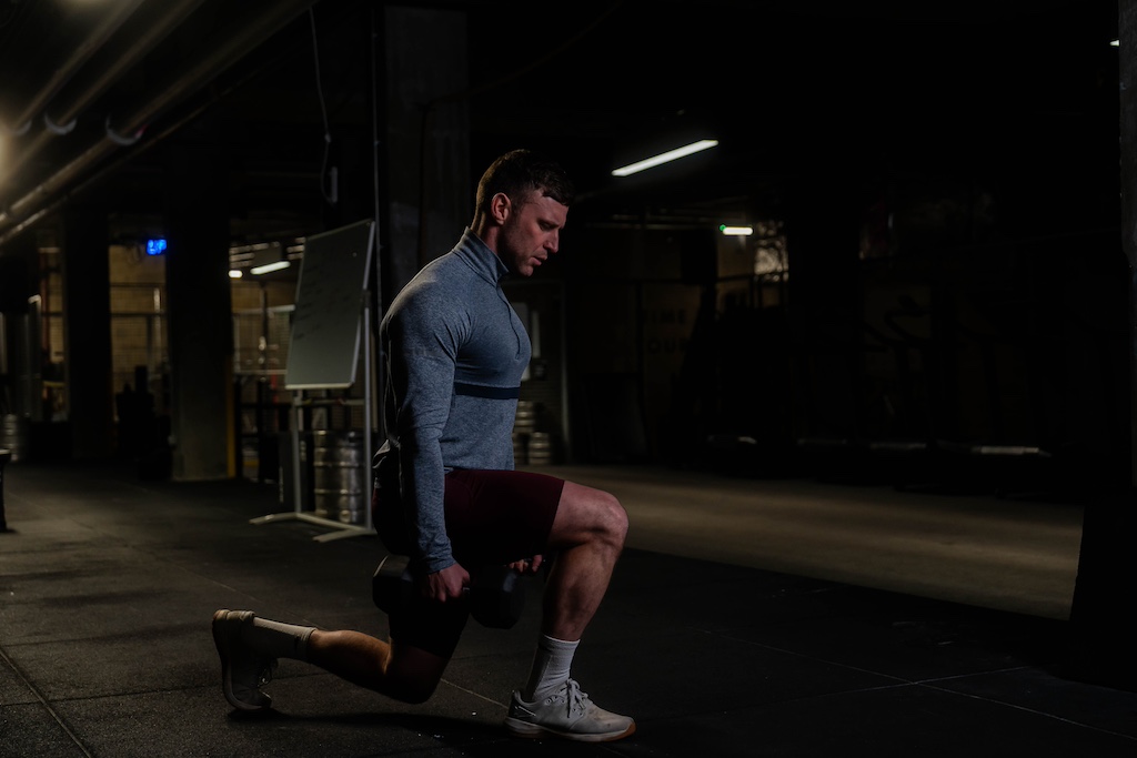 man performing dumbbell reverse lunge