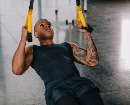 man doing inverted row suspension trainer abs exercise